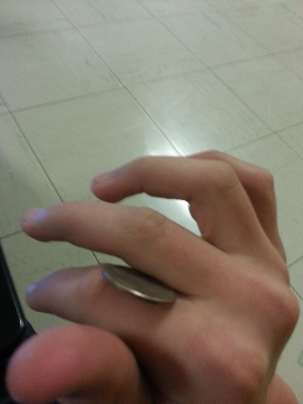 Hit the coin gently to make it roll onto your middle finger.