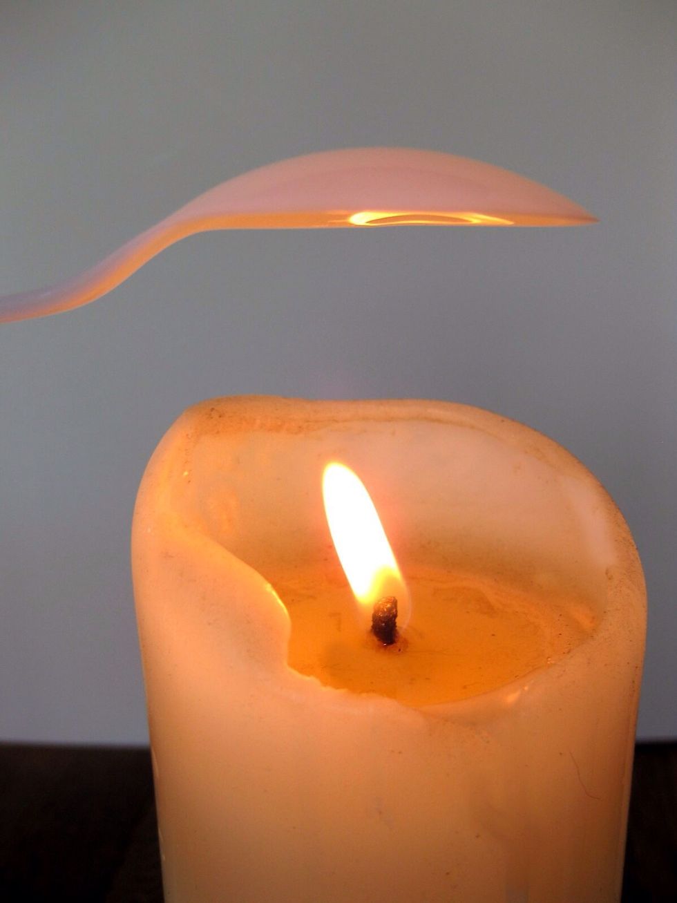 Hold a plastic spoon about an inch above candle; Heat for about 5 or 10 seconds until it starts to melt. Take it off the flame and gingerly fold it to resemble a rose bud. Make 2 of these