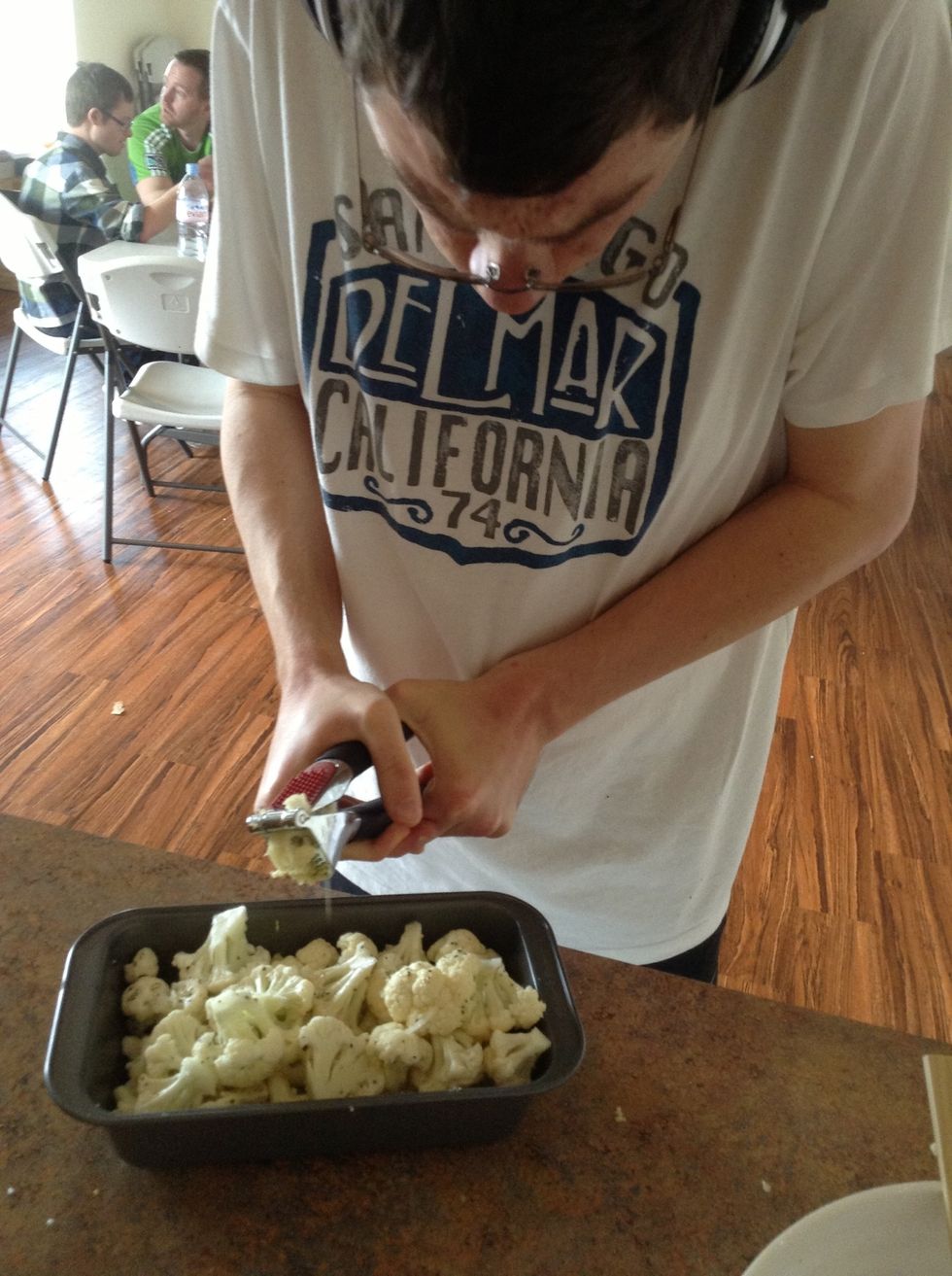 Hold garlic press over baking dish and squeeze handles together mince garlic. Make sure to the garlic even over the cauliflower