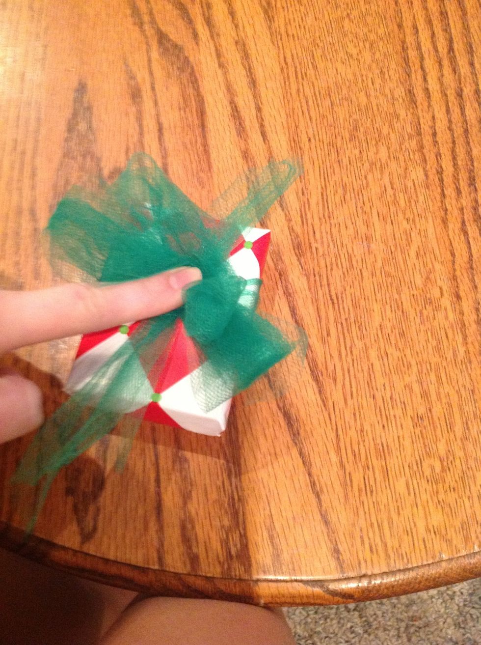 hold it in the center of the folds and place it directly onto the knot of the tied piece