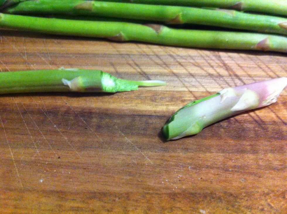 Hold on either side between two fingers on both hands and do the "bend and snap" ! :) It knows where to break on its own leaving only the tender bit behind; there's no need to use a knife