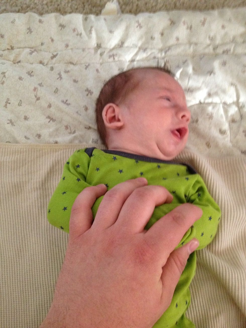 Hold the Baby's arms down toward their belly.