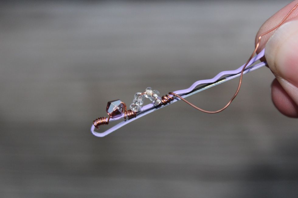 Hold the beads in place as you fold over the wire to make a "rainbow" like shape (or what ever you want to call it) :P and wrap again.