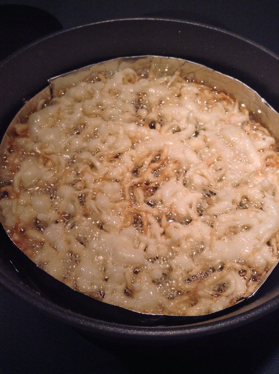 Hold the bottle of batter close to the surface of the oil, and squeeze a generous half a cup of the batter into the oil while making a circular motion.