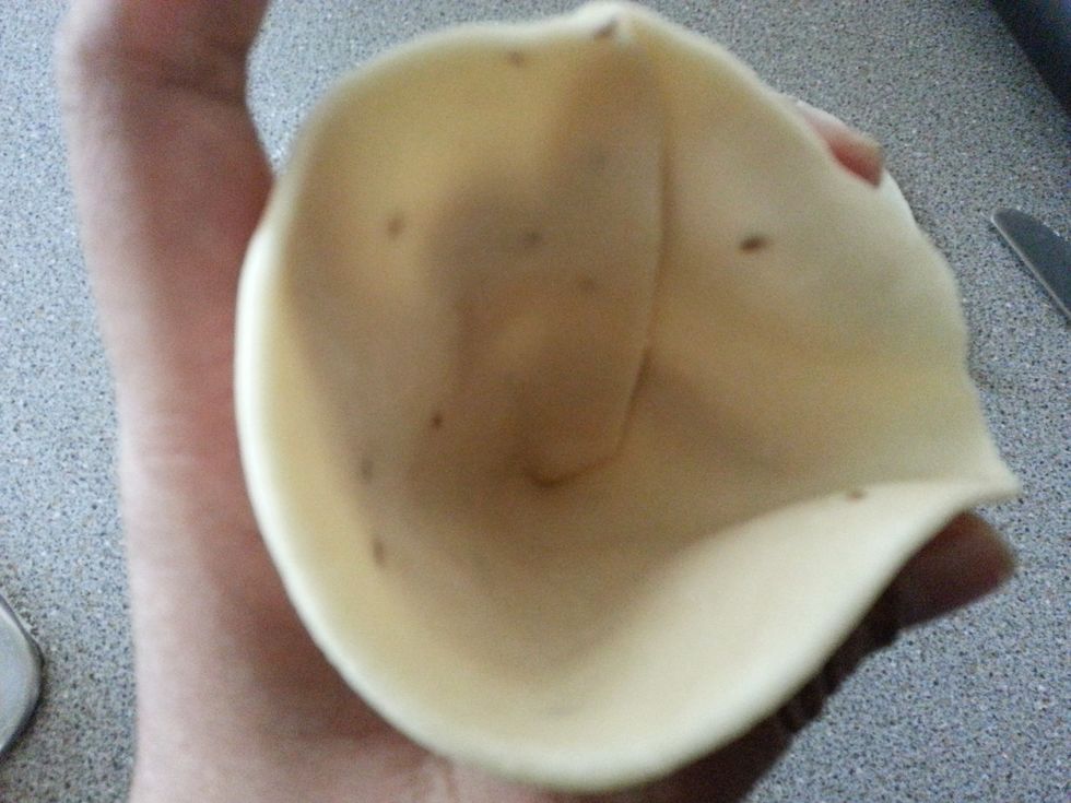 Hold the cone in your left hand and fill it with the stuffing. Close it by folding the open part on the top and seal it with a little water