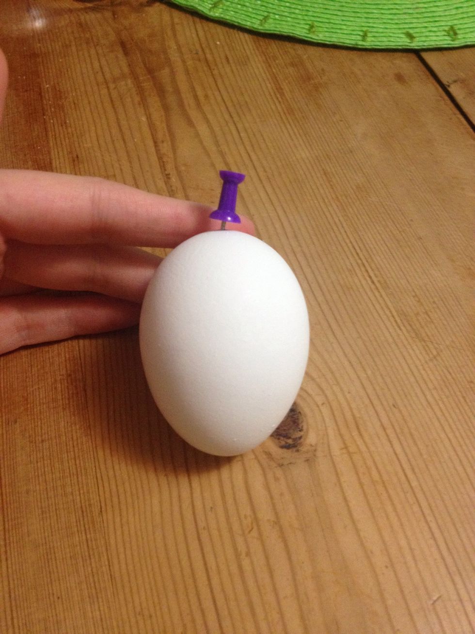 Hold the egg vertically. Using the pin, poke a hole in the end of the egg. BE CAREFUL TO NOT GRIP EGG TO HARD WHILE HOLDING IT!