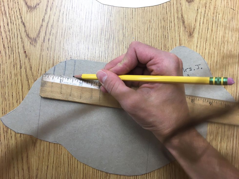 Hold the end of the ruler back at my beginning line and the ruler is on the animal. Measure every half inch on the ruler and make a mark. Turn the animal and do the same to the other side.