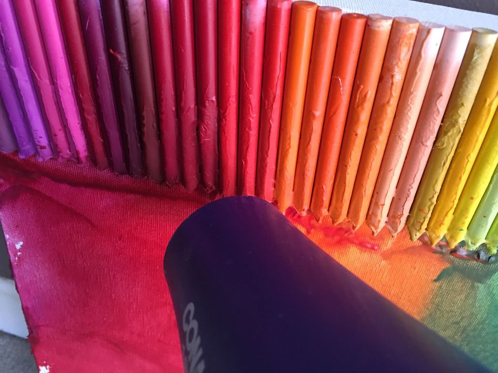 Hold the hair dryer close to the crayons and wait for them to start melting.
