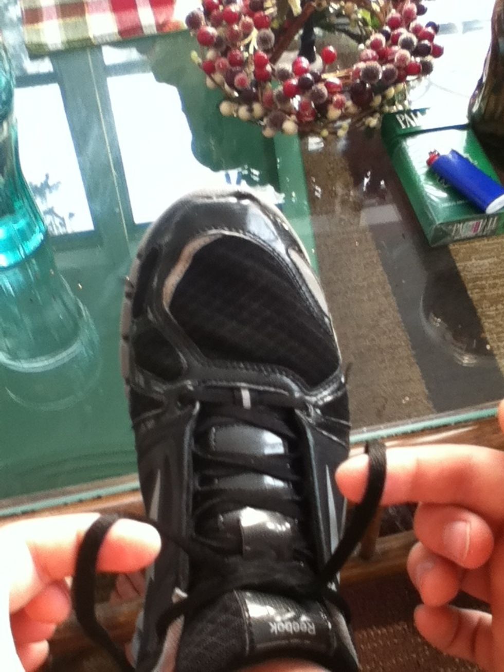 Hold the laces so the right one is hanging forward and the left one is hanging backwards.
