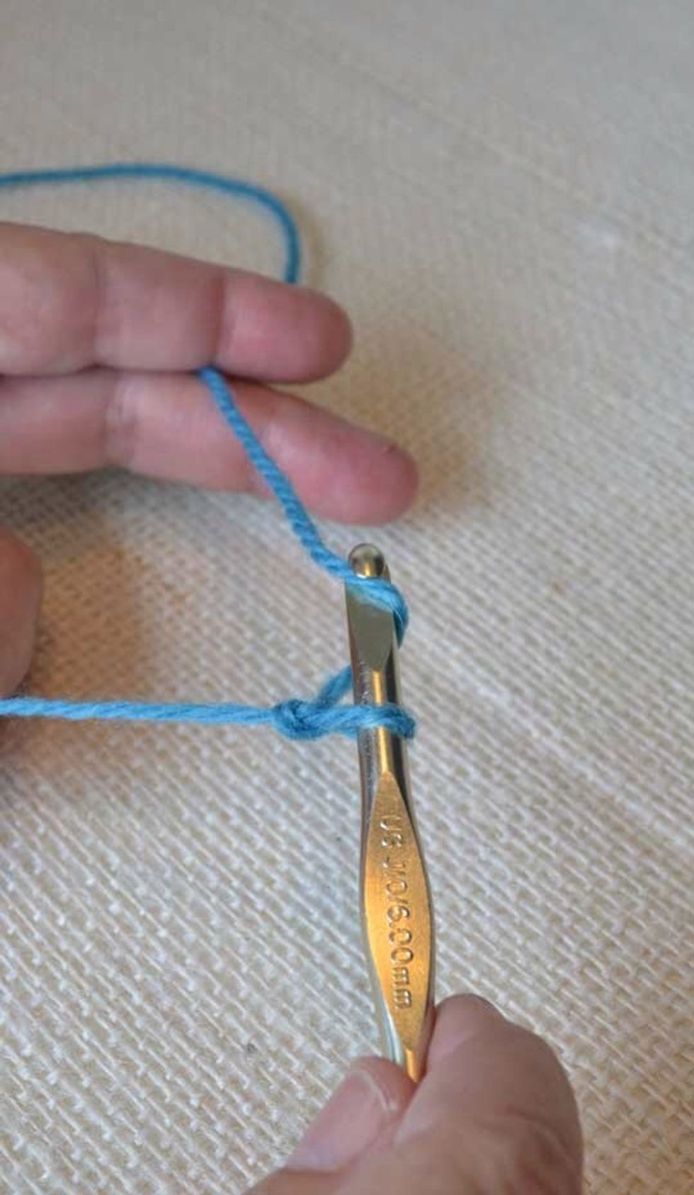 Hold the loop where the two pieces meet, then create another loop from the ball end and feed it back through the first loop.