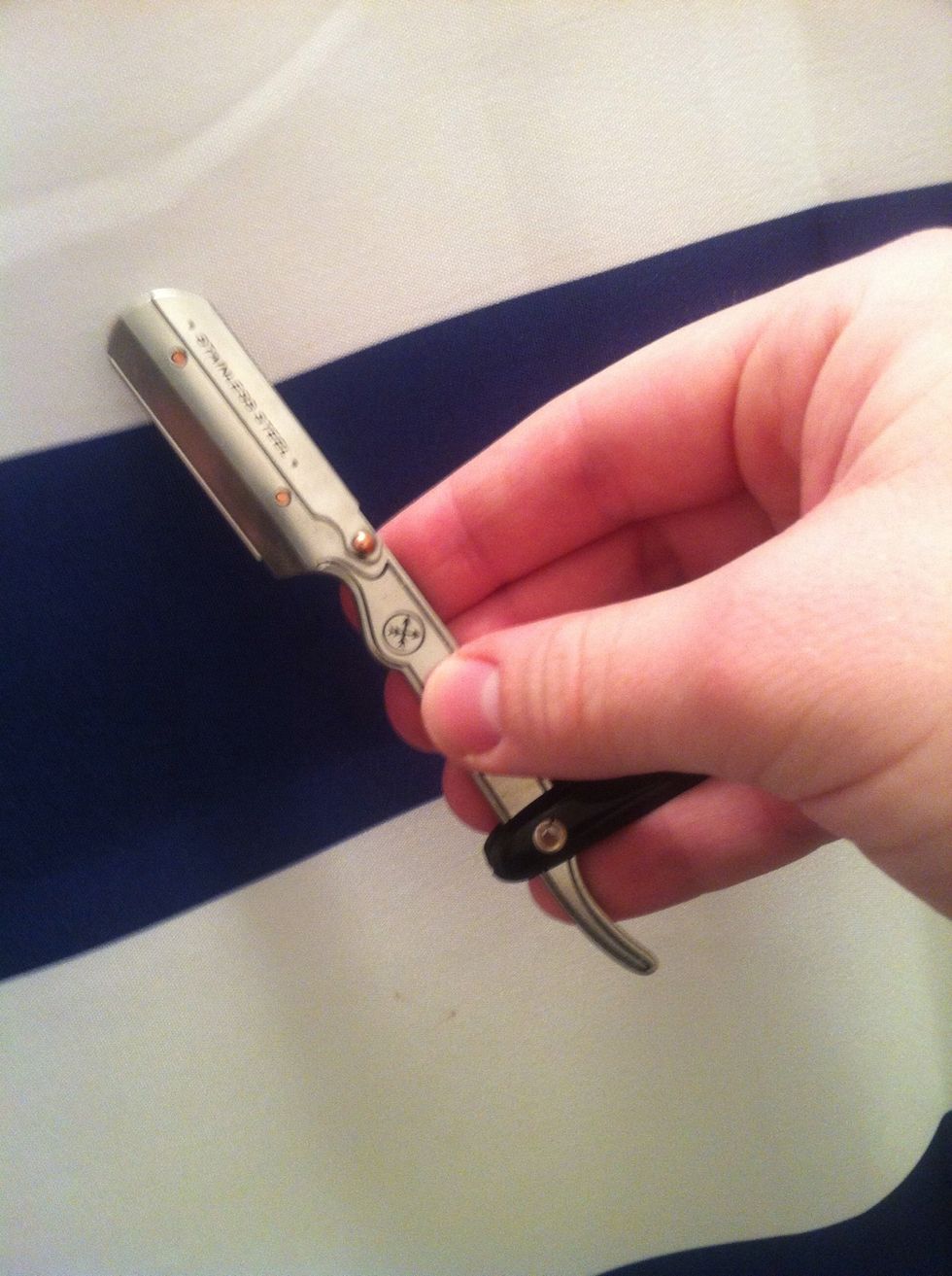 Hold the razor in your dominant hand balanced with the handle between your ring and pinky fingers and your pinky resting on the tang of the razor.