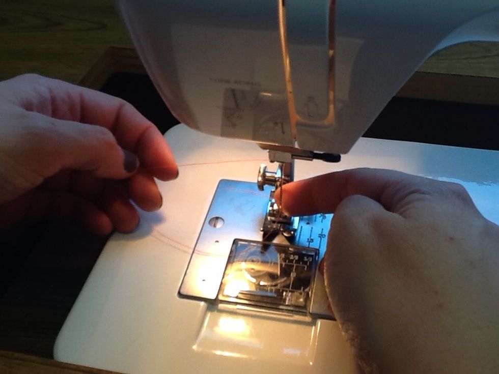 Hold the thread off to the left so it doesn't wrap around the needle.