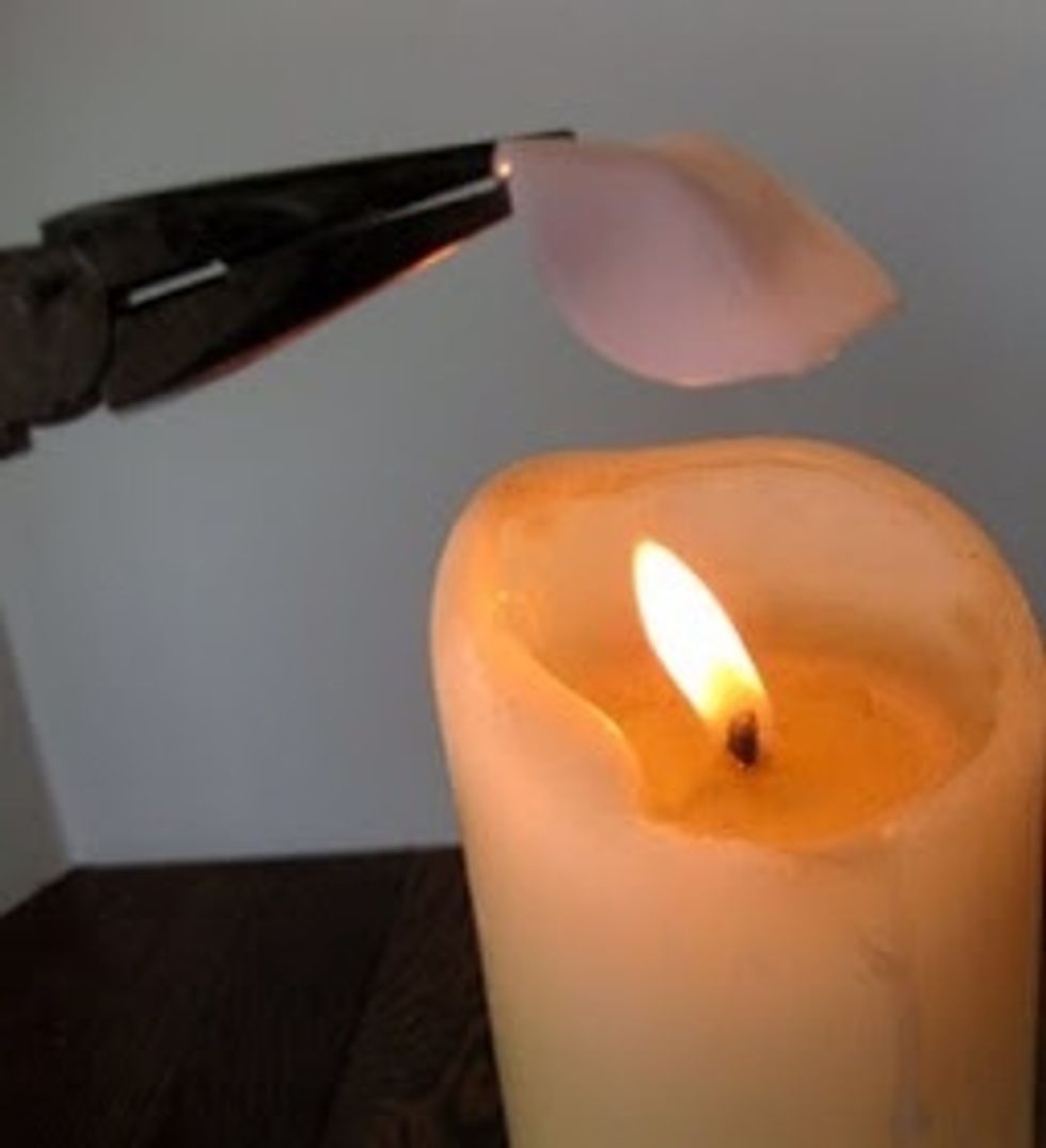 Hold the tip of the petal with the pliers and heat the place on the spoon where the handle was until it begins to melt. Place it on the rose, wait until it cools and sticks.