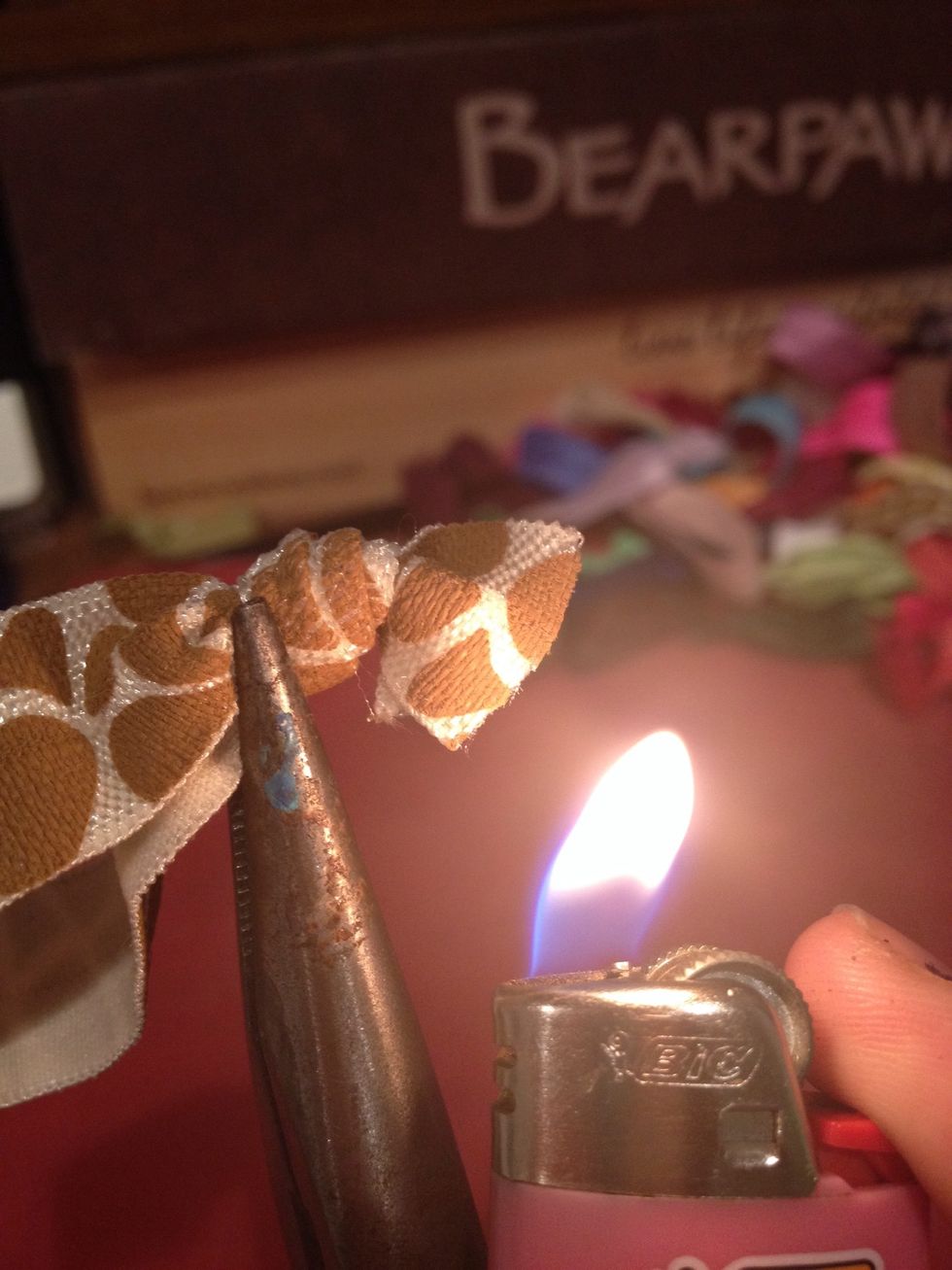 Hold the tips up NEXT to a flame to melt the elastic. If you put it in the flame it can burn and give you a darker color. I actually like his sometimes but it's a personal opinion, do what you like :)