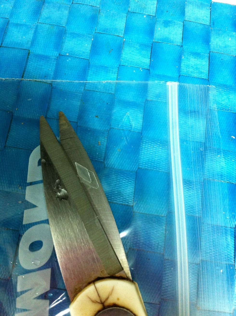 Hold the zipper bad with your hand and cut the hole with the scissors in upper corner, right or left dosen't matter