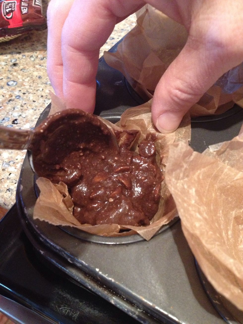 Hold them down if you have to and using a table spoon, spoon the batter into the parchment cup, if you will....