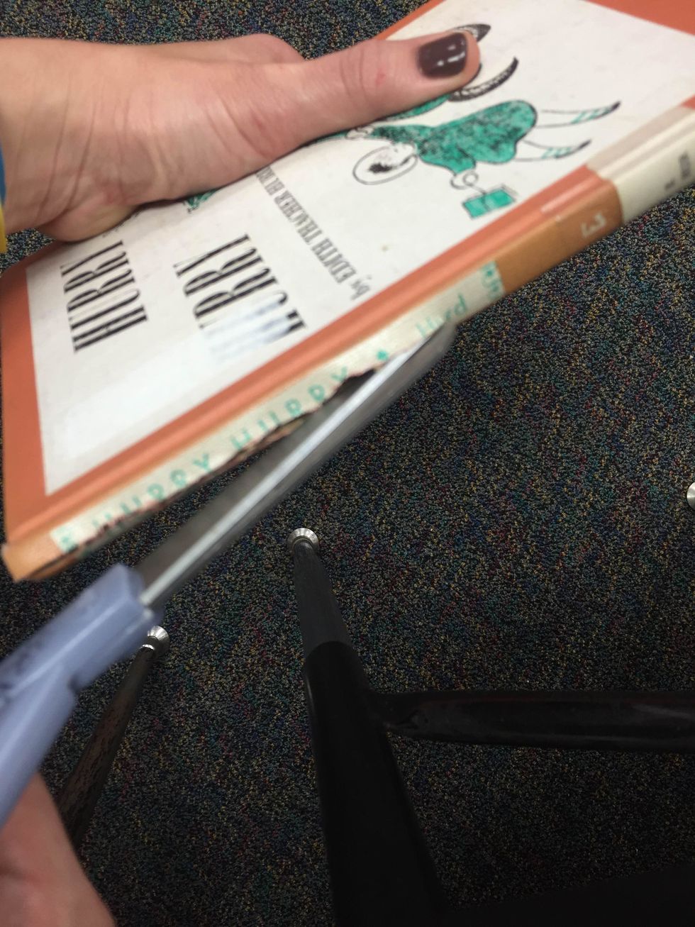 Hold your book underneath when cutting the spine. This will keep your hand safe in case that your scissors slip.