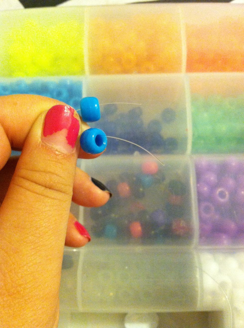 Hold Your string so that both ends are like shown \ud83d\udc46and add a bead to each side .