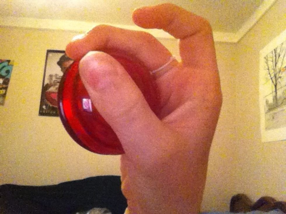 Hold your yoyo with your finger with the string around it on the slit.