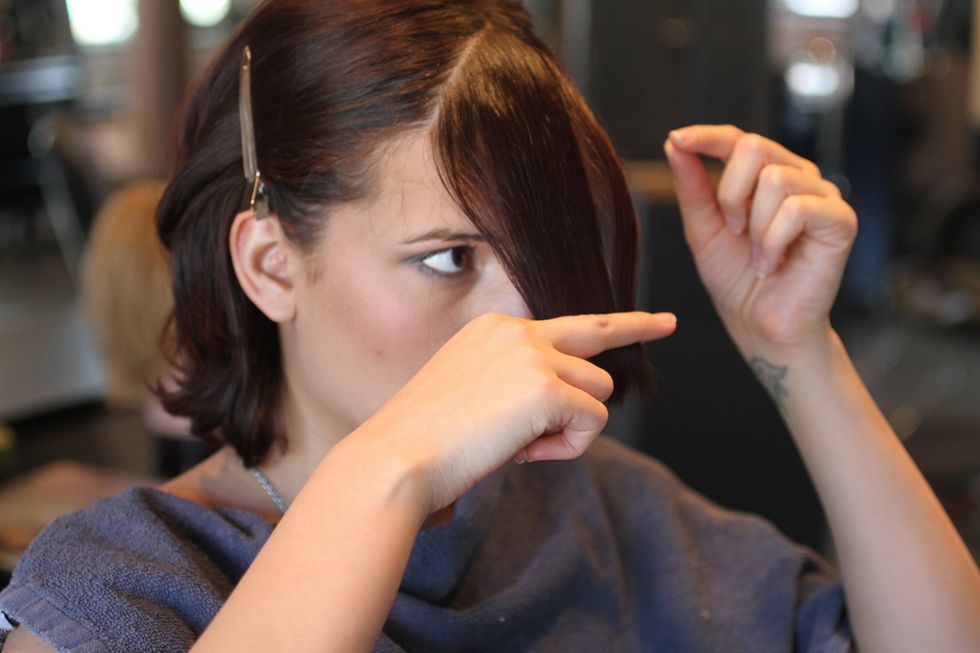 Holding bangs between fingers, pull them 3" away from your face. The hair will pull up, becoming shorter at the cowlick, so pull up the hair beneath it about a quarter-inch, creating less tension.