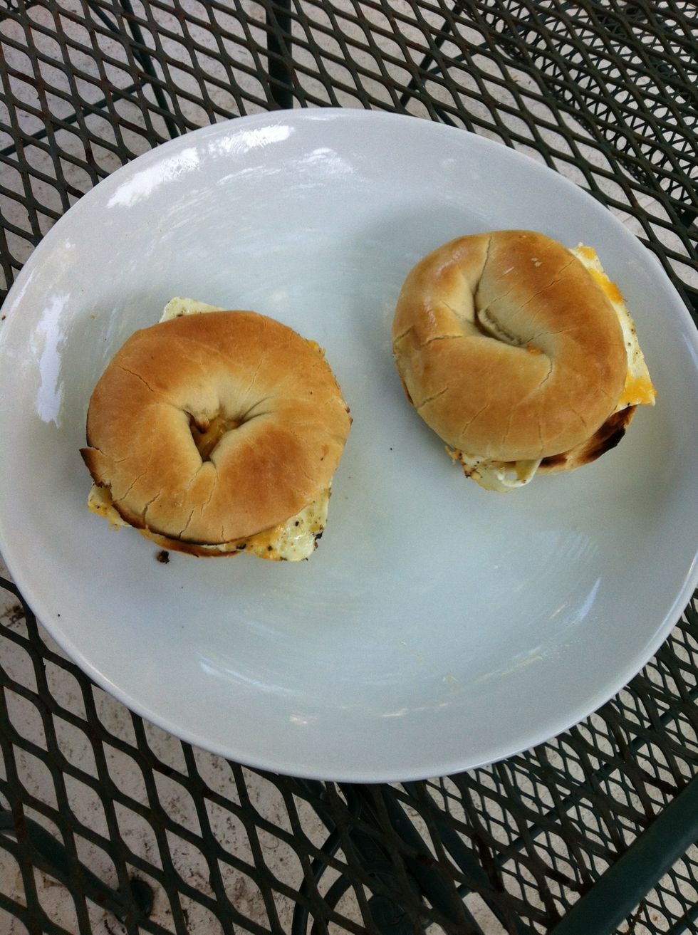 Holding done foil with one hand use spatula to scoop out egg and top each bagel bottom. Add bacon and bagel top.