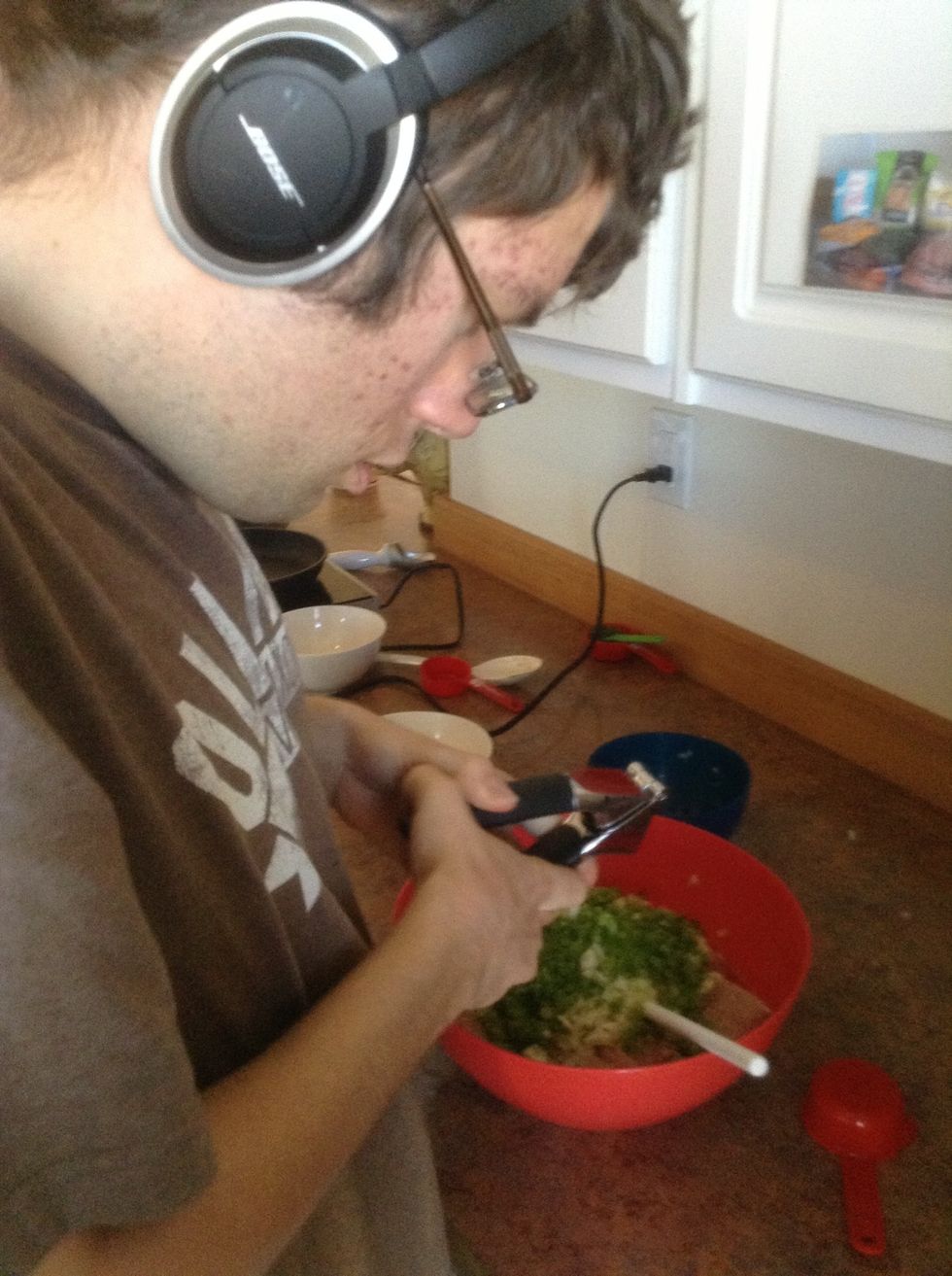 Holding garlic press over the bowl put 1clove at a time into the garlic press. Press the handles together.