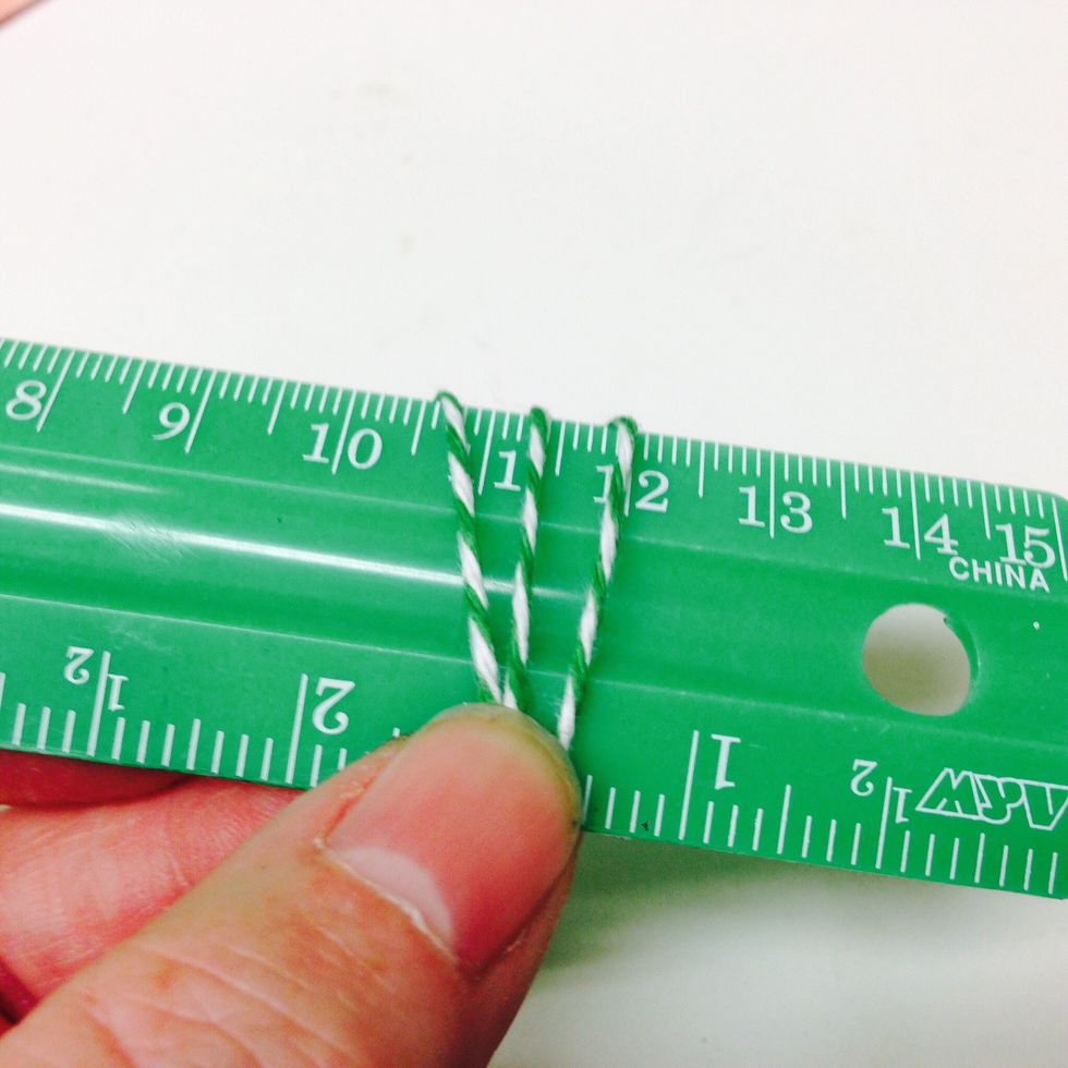 Holding the ends in place, wrap the baker's twine around a ruler or 1 inch piece of cardboard.