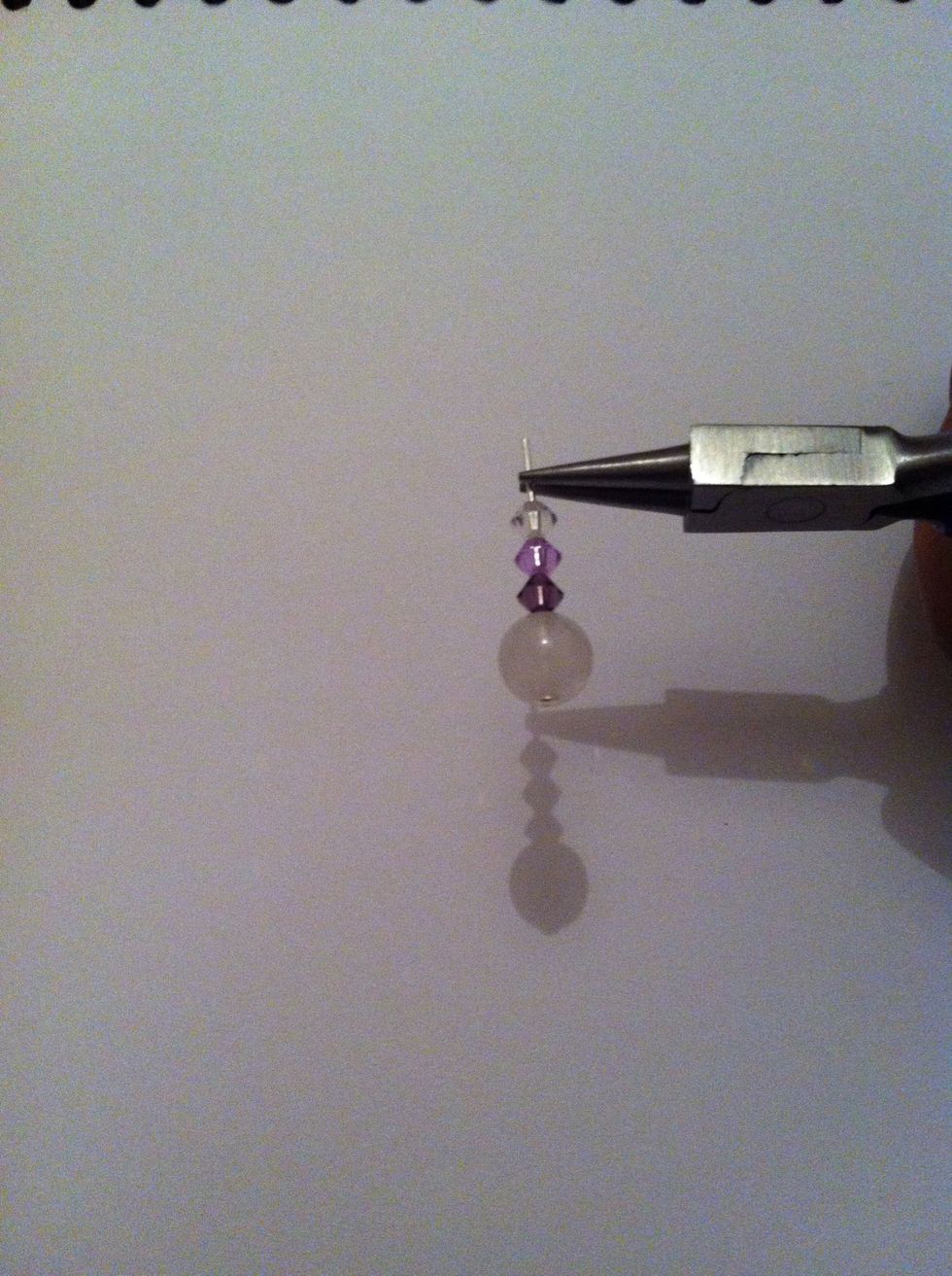 Holding the head pin and beads with your left hand, grip the head pin with the pliers about 2mm after your last bead (I'm using my left hand to take the pic!!)