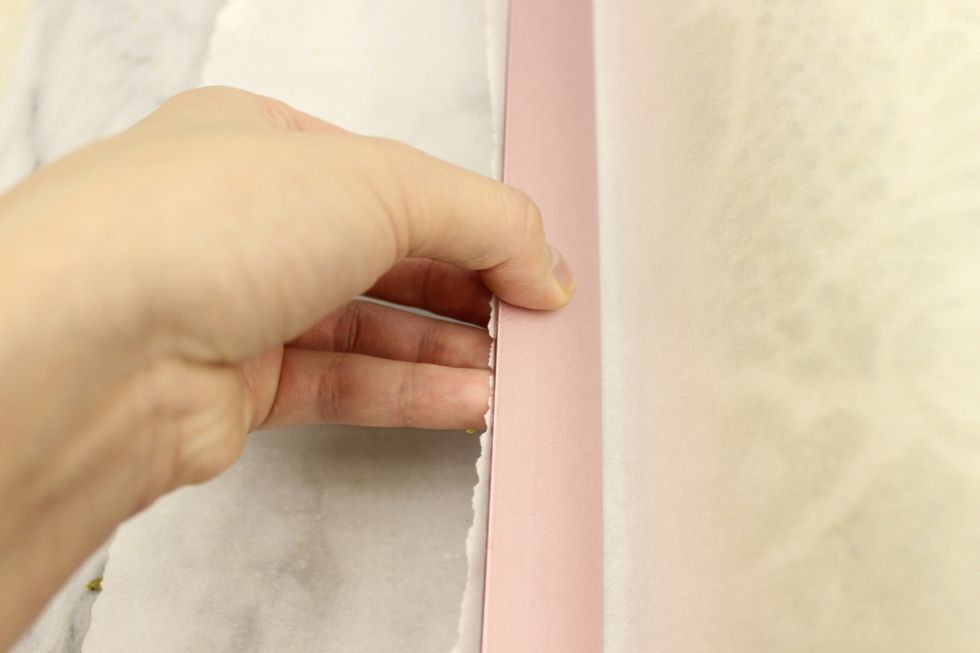 Holding the ruler and tab together, tightly tuck it underneath the roll. This helps to straighten and tighten your roll. This whole step is optional.