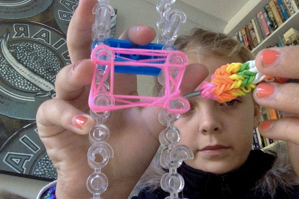 Hook the bottom 2 band over the peg an drop it.