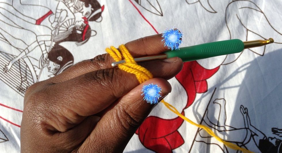 Hook the working yarn as shown and pull up a loop going under the tail end of the yarn.