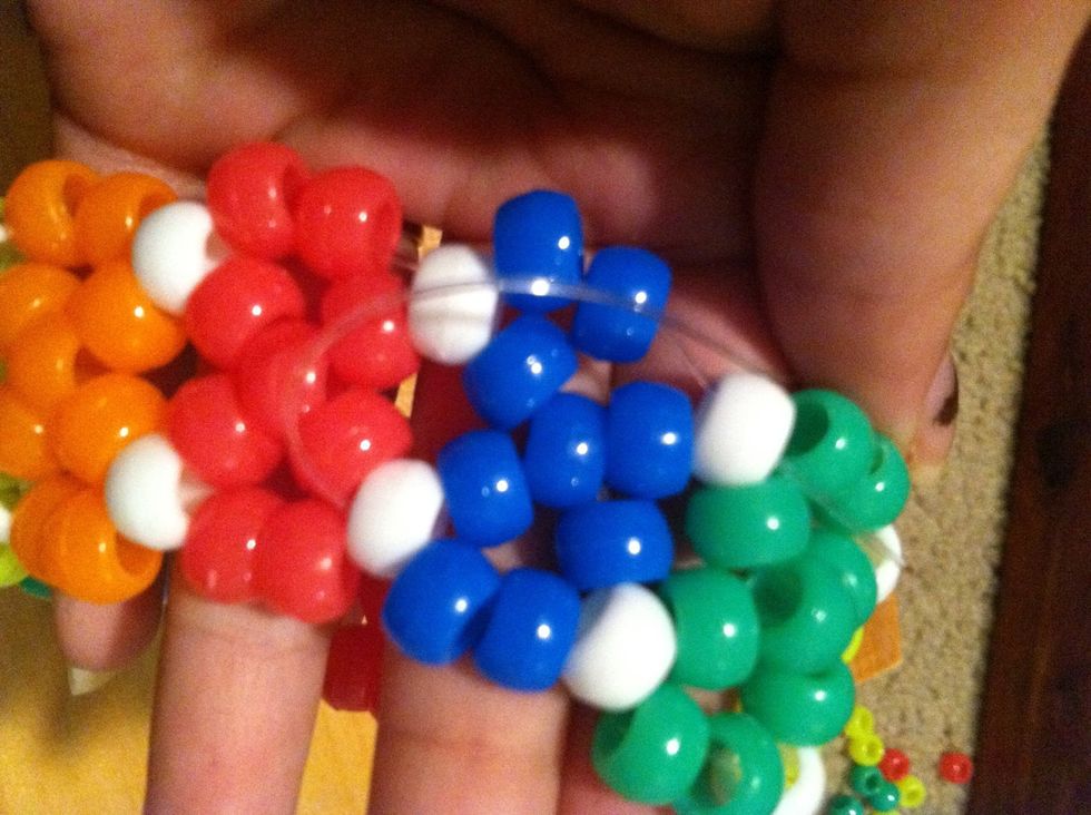 Hopefully you can see both strings. That first small string when you first tied your bracelet is to be navigated through the beads until its close to the longer string.