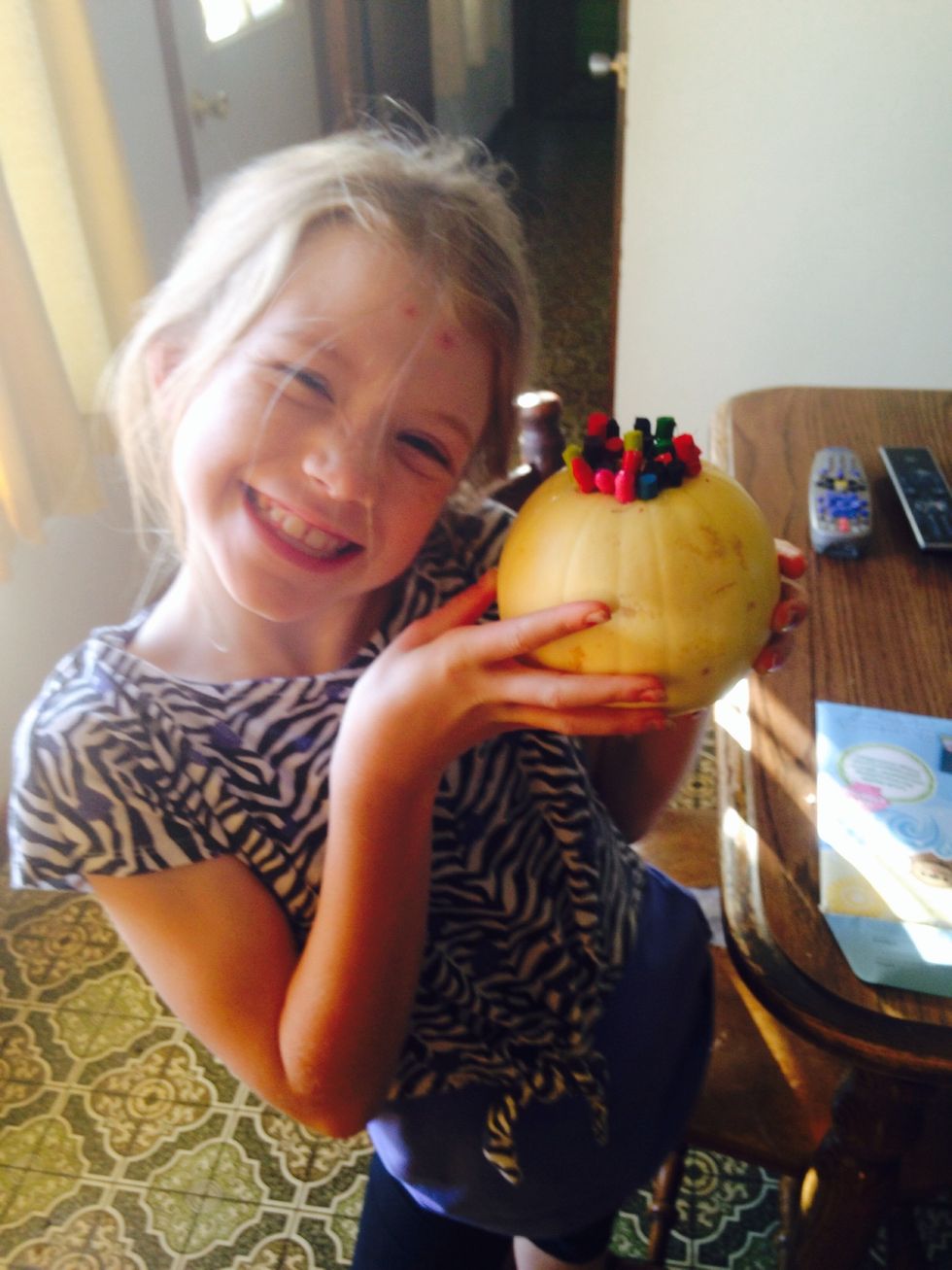 Hot glue crayon pieces to the top of the little white pumpkin