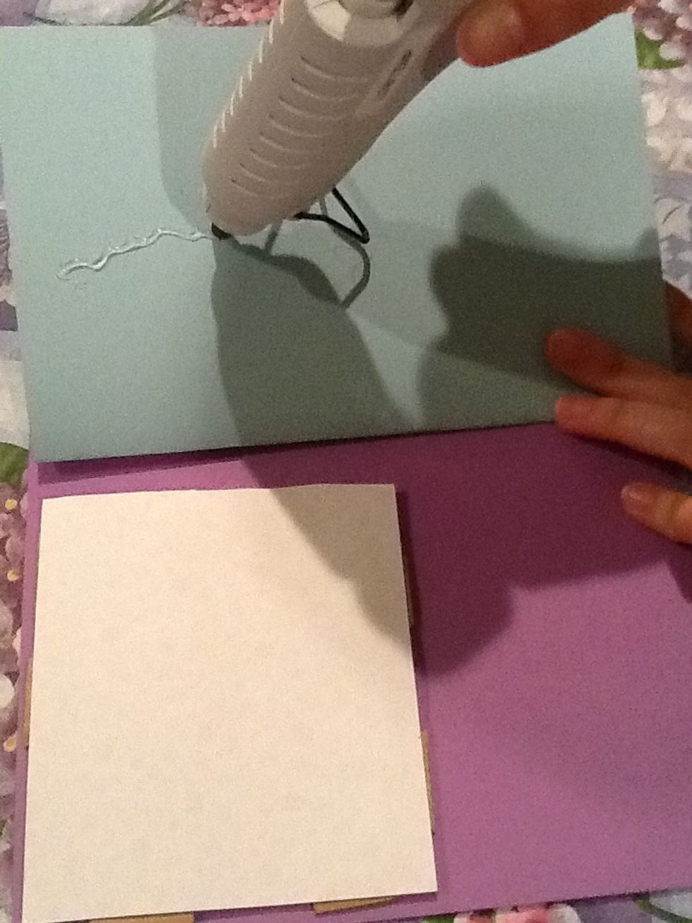 Hot glue the last piece of paper that you haven't used yet to the pieces of cardboard. Then glue the piece you wrote on over both cards.