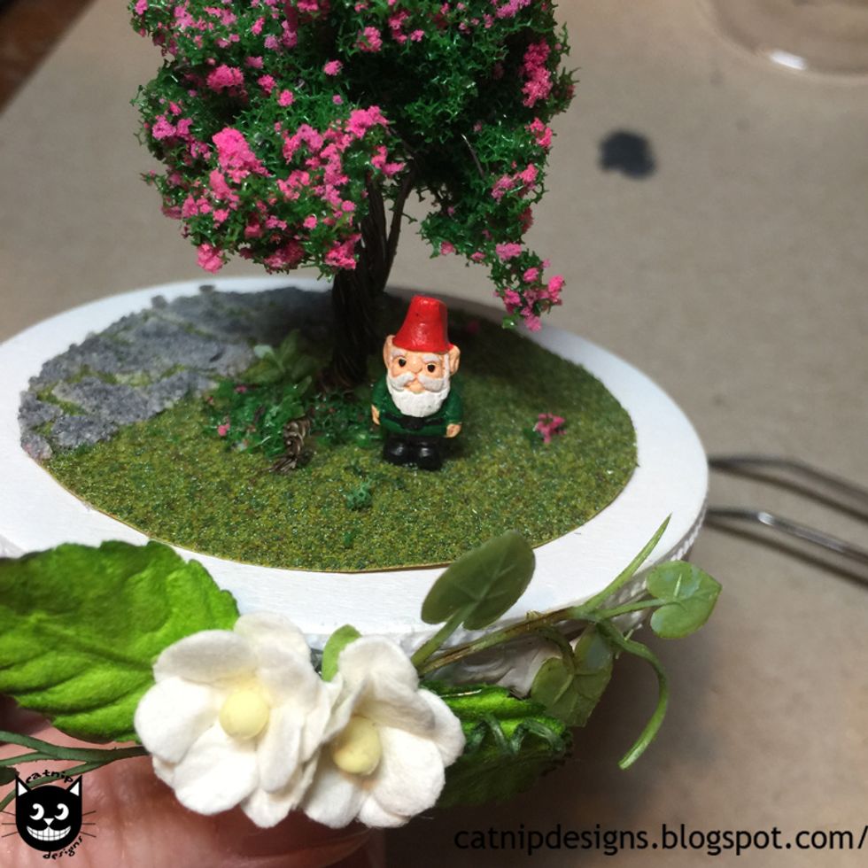 Hot glue the Mini Ceramic Garden Gnome Bead where you think it looks best.