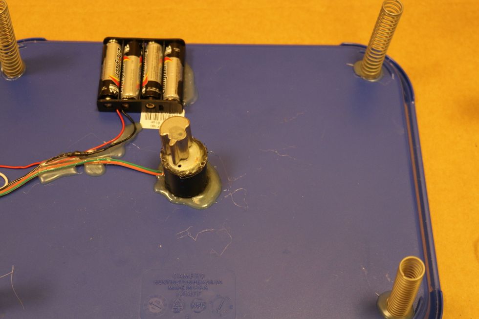 Hot glue the motor to the center bottom of the tray. Then hot glue the batteries holder next to the motor.