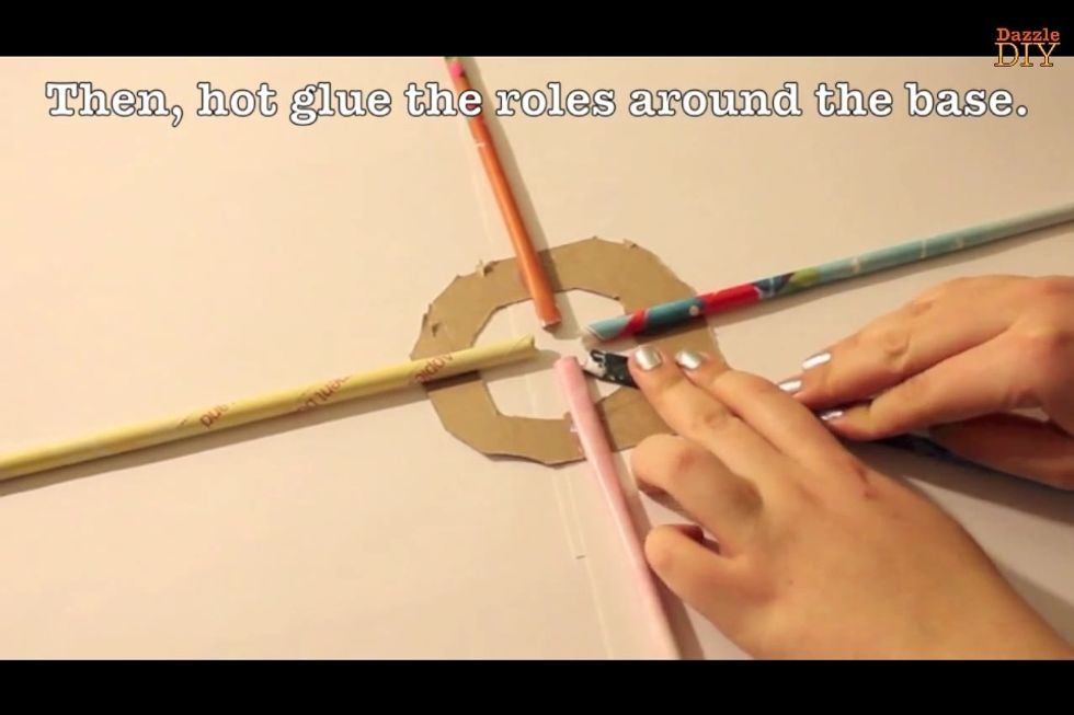 Hot glue the roles around the base