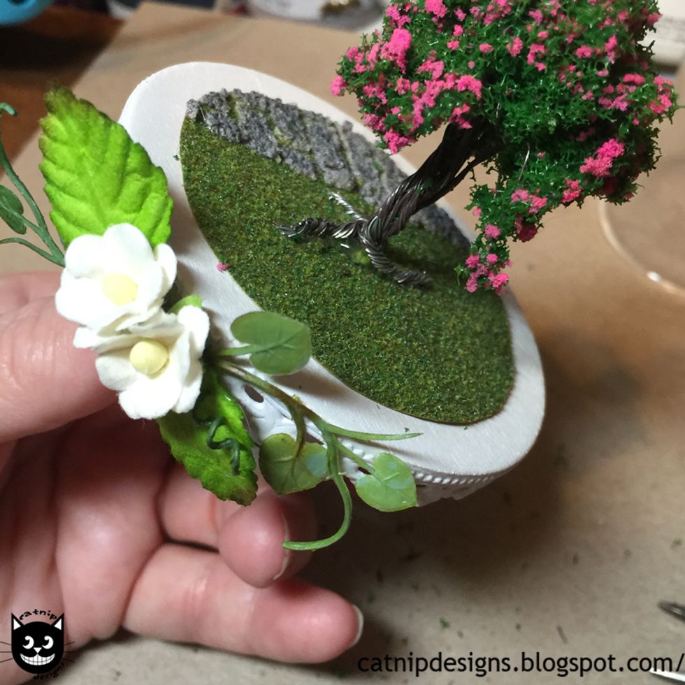 Hot glue the roots to the grass.