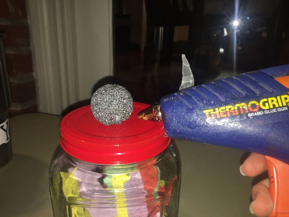 Hot glue the silver styrofoam ball to the center of the jar's top.