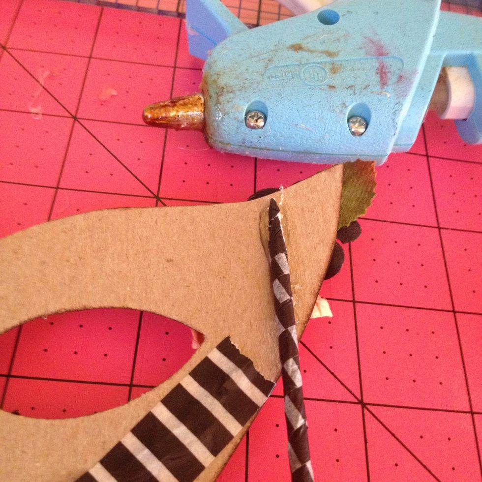 Hot glue the skewer onto the back side of the mask