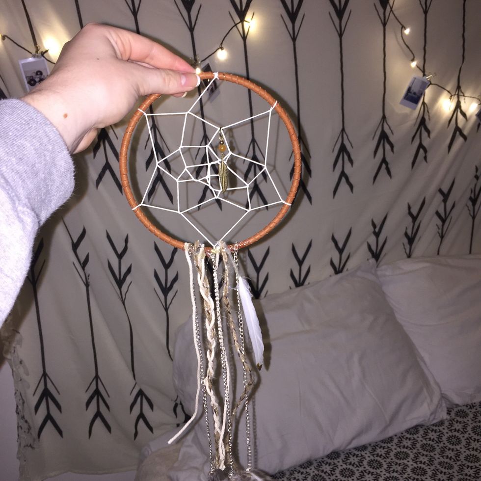 Hot glue them on. Occasionally pick up the dream catcher to see where you might need to fill in the spaces.