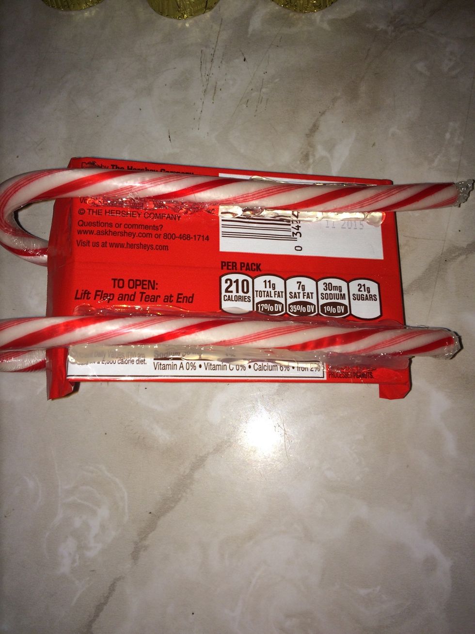 Hot glue your two candy canes to the bottom of your kit Kat bar