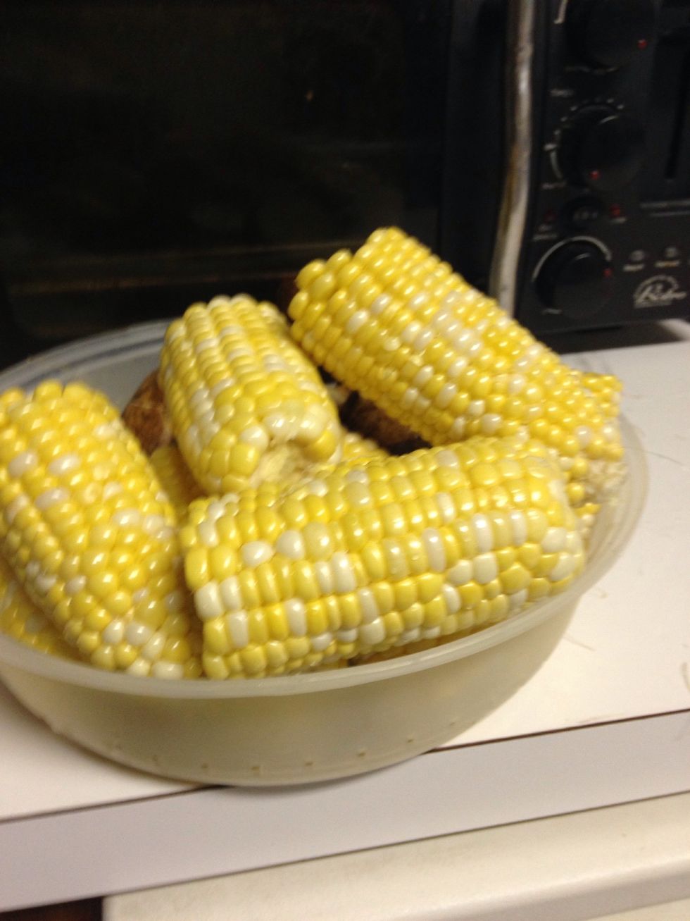 Husk and clean the corn. Then break in half like so