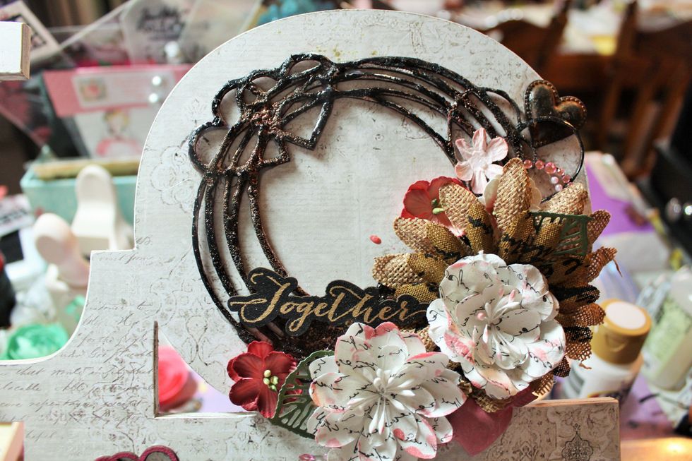 I added a Prima metal heart along the top & a few more smaller flowers to complete the cluster w/ some more Prima forest leaves. I cut apart the Prima Say It in Pearls piece & tucked in a few swirls.