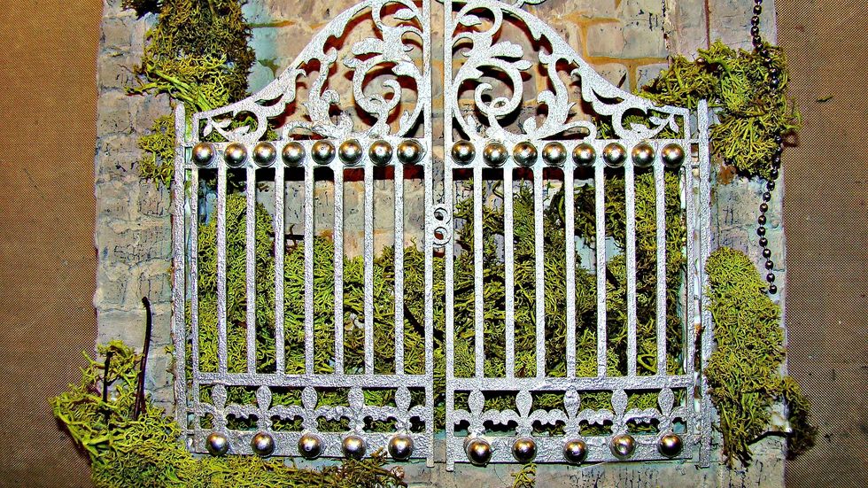 I added flat side pearls to my gate and paint the entire piece with Metal Effects Silver and smudged with black soot DI. Glue your reindeer moss to the inside of the canvas and attach your gate.