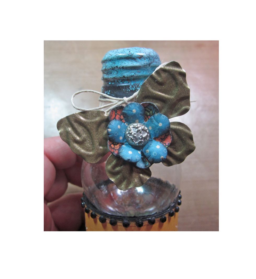 I added some embossed metal butterflies, flowers and brads from the Graphic 45 Staples collection. I also added in some twine and rhinestone strips to pull everything together.