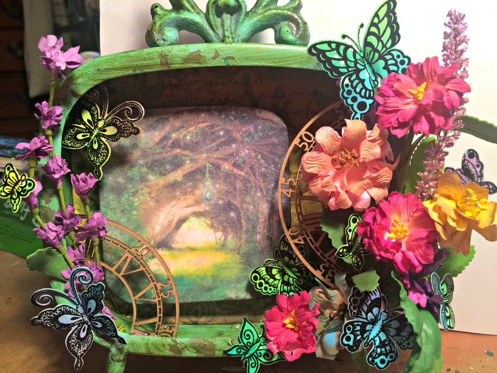 I added the longer flowers on the left. Cut my chipboard time piece in half and glued it in place with hot glue. I then added all of those beautiful butterflies. I used hot glue to adhere them as well