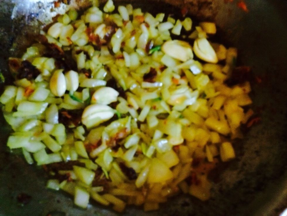 I added whole cloves of garlic that were smashed to the onions. See the shiny onions. They're sweating. Remember to scrape the pan for the bits! But when they start to brown pour out in big pan.