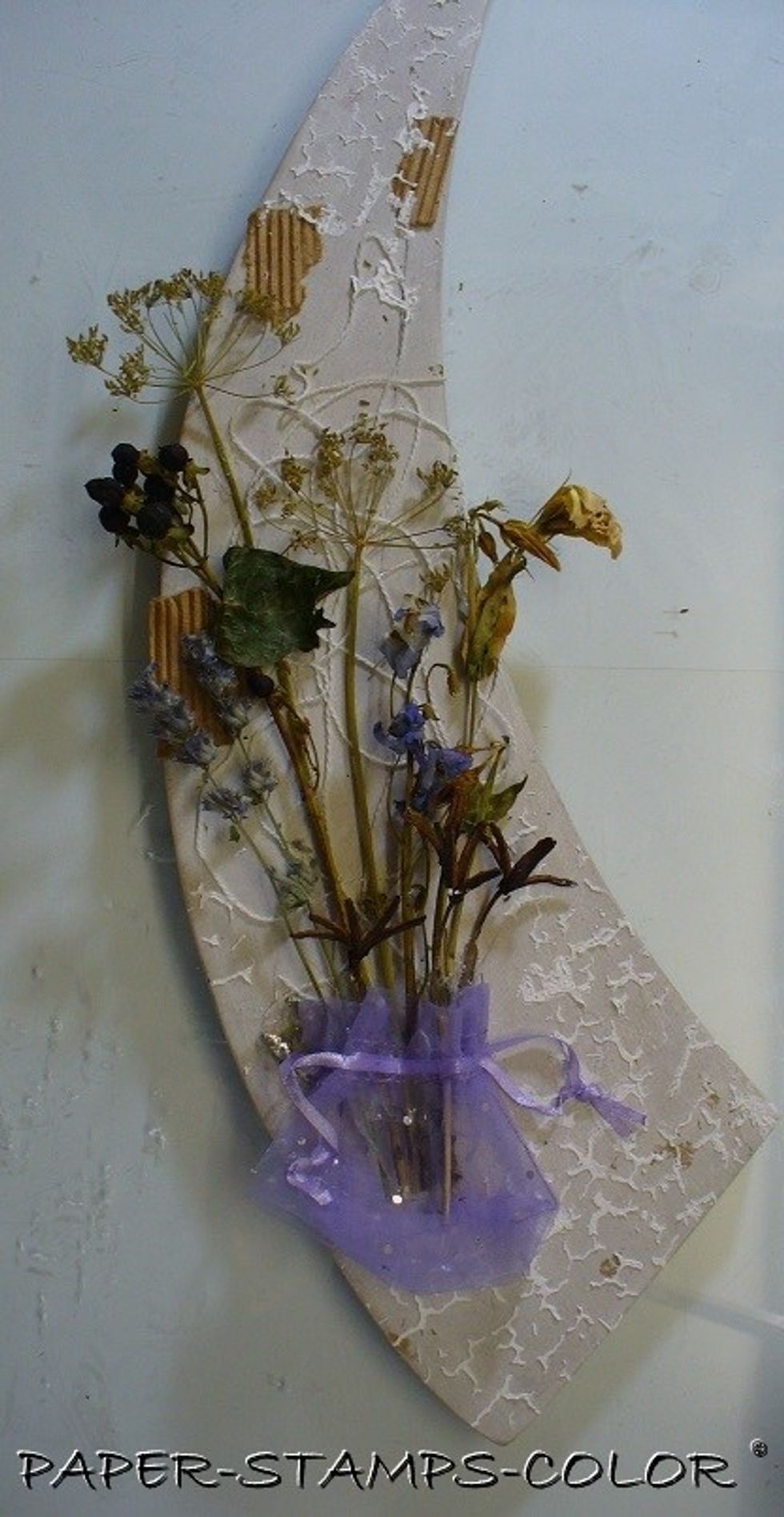 I added yarn, pieces of corrugated cardboard, a 'bag' from my stash to hold the stems. Assemble everything with hot glue. Add structure paste with the Cracked Stencil to add ineterest.