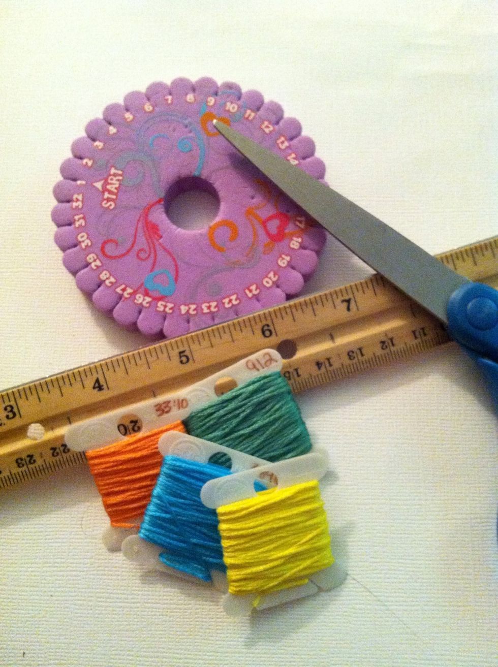 I am using embroidery floss for this example. The purple disk is a stiff foam loom, called a Kumihimo (koo-me-he-moe) wheel or disk. It can be purchased in craft stores or online.
